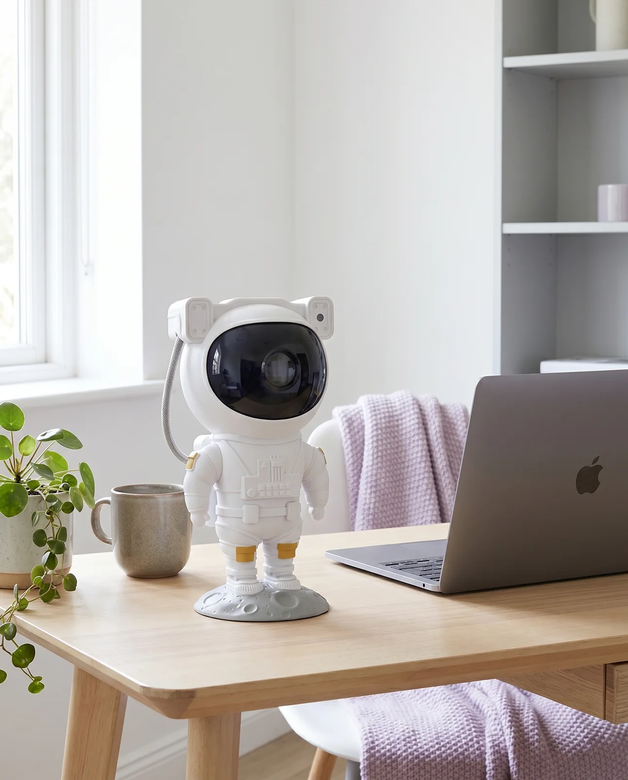 The astronaut standing as a desk ornament next to a laptop in daylight